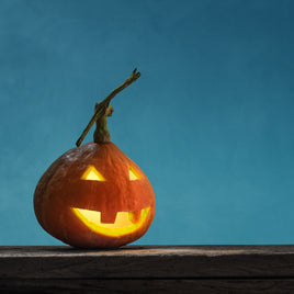 Carved pumpkin jack-o’-lantern glowing in the autumn darkness