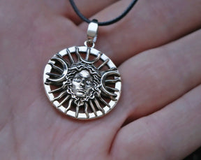 Silver Hecate necklace with triple moon pendant on a hand
