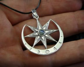 Silver star of Ishtar with inlayed moonstone pendant held in hand