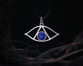 May include: Silver pendant necklace with a blue lapis lazuli stone in the center, shaped like an eye with a triangle inside.