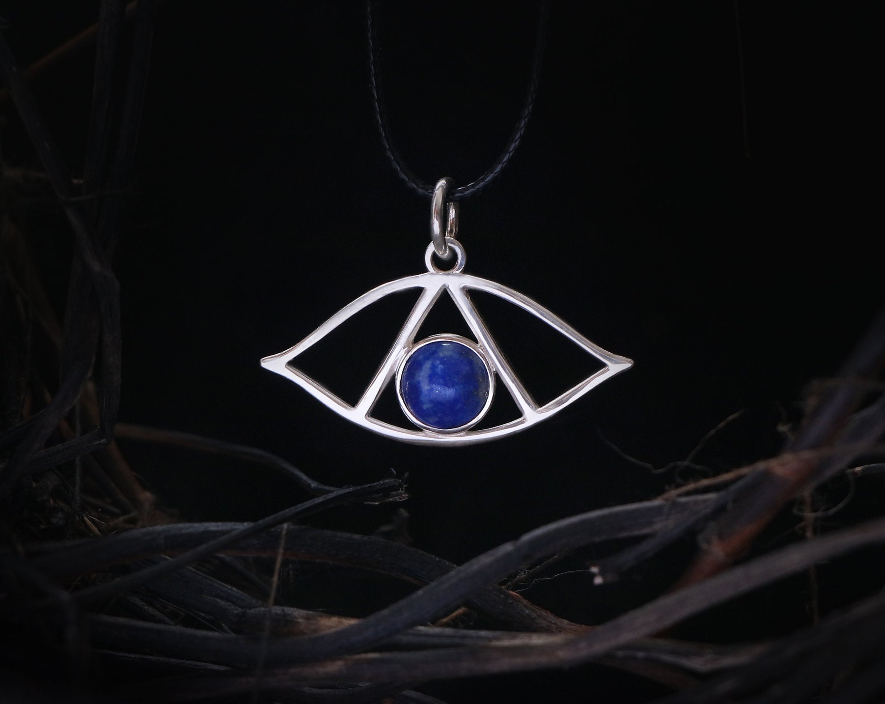 May include: Silver pendant necklace with a blue lapis lazuli stone in the center, shaped like an eye with a triangle inside.