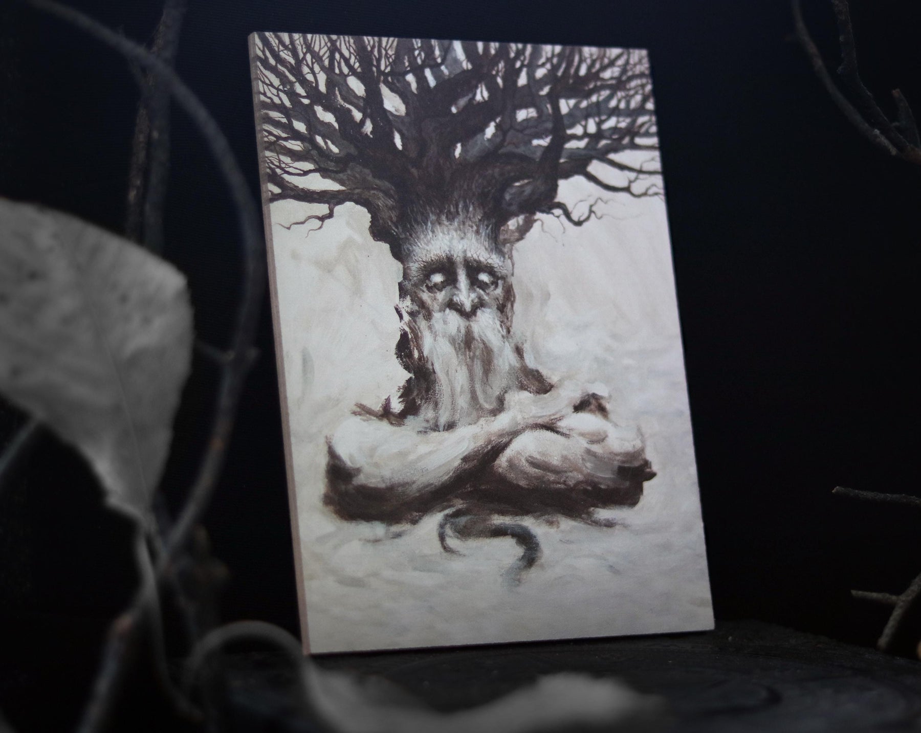 May include: A painting of a tree spirit with a weathered face and a long beard. The spirit is depicted with its arms crossed and a tree trunk growing out of its head. The painting is done in shades of brown and white.