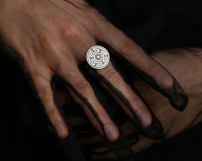 Sterling silver Hecate ring on a hand in a black mesh glove. Adjustable occult jewelry featuring the Strophalos of Hekate.