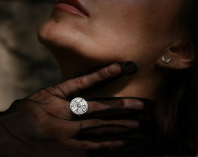 Close-up of an adjustable sterling silver Wheel of Hecate (Strophalos) ring on a gloved hand, paired with a tiny crescent moon earring. A complete Pagan Workshop set for those embracing goddess worship and gothic minimalist style.