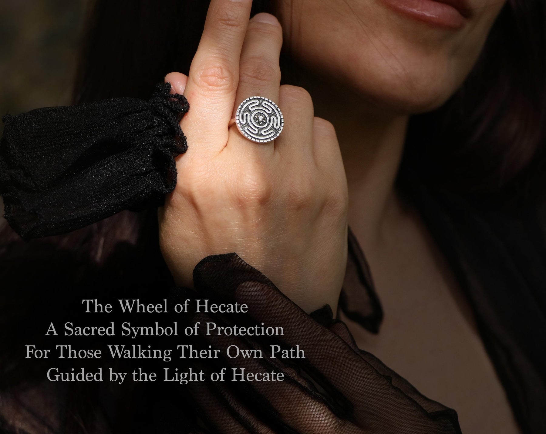 May include: A silver ring featuring a circular design with a maze-like pattern and a central stone. The ring is worn on a finger. The text on the image reads: "The Wheel of Hecate, A Sacred Symbol of Protection, For Those Walking Their Own Path, Guided by the Light of Hecate."